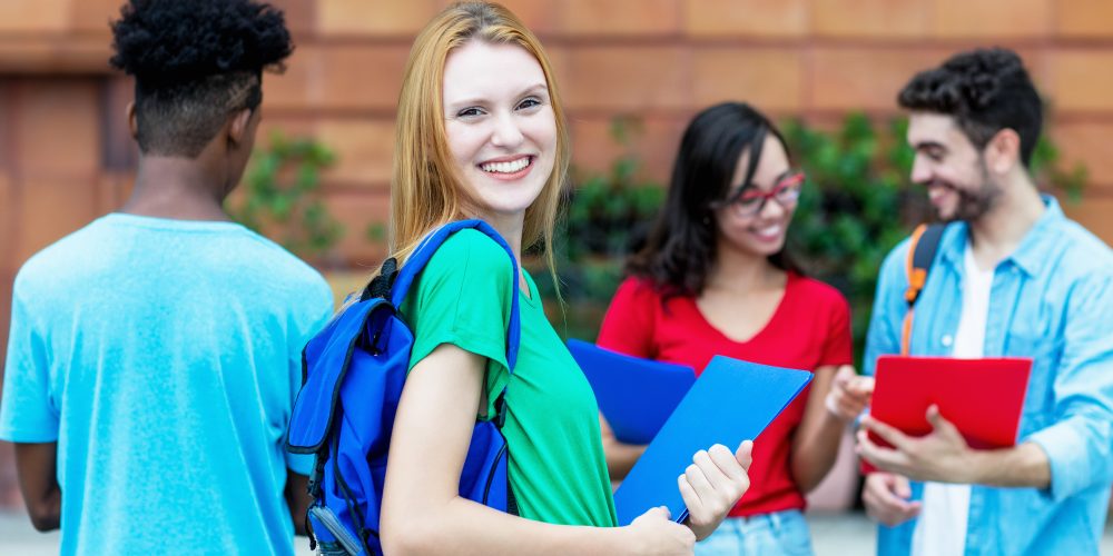 Laughing British female student with group of students