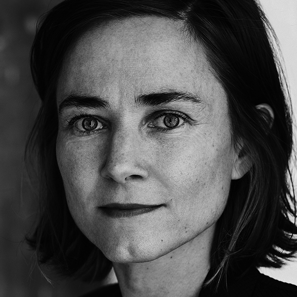 Retrato en blanco y negro de una mujer adulta, de rostro redondo, con cabello castaño corto y ojos marrones. Tiene una expresión serena y se observa una ligera sonrisa.