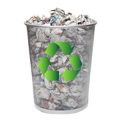 Un cubo de basura metálico con el símbolo de reciclaje. Contiene papeles de diferentes colores y texturas.